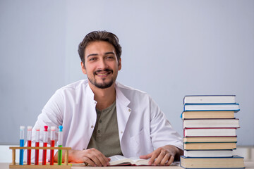 Young male chemist teacher in front of whiteboard