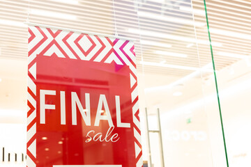 Sale sign at the entrance to clothing store - large red panels with white words. Seasonal discount offer in store. Discounts and black friday concept.big reductions