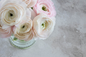 Bouquet of soft pink ranunculus flowers in a glass vase,top view