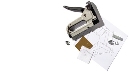 Silver furniture stapler gun with staples and the drawing of the armchair. Manual industrial tool....