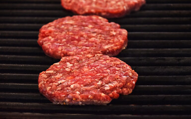 Raw beef burgers for hamburger on barbecue grill