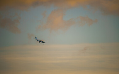 Cessna 208b Grand Caravan G-CPSS light aircraft returning to land, moody sunset sky