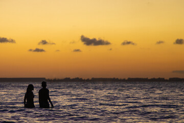 Fototapeta premium Pareja de novios disfrutando del 14 de febrero en playas de Isla Mujeres al atardecer. 