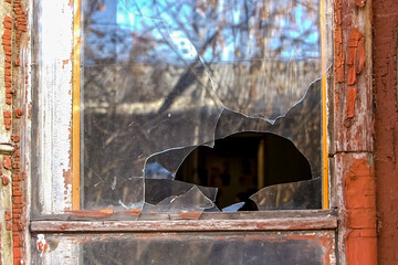 broken glass in the window of an old abandoned house, photo from outside the house