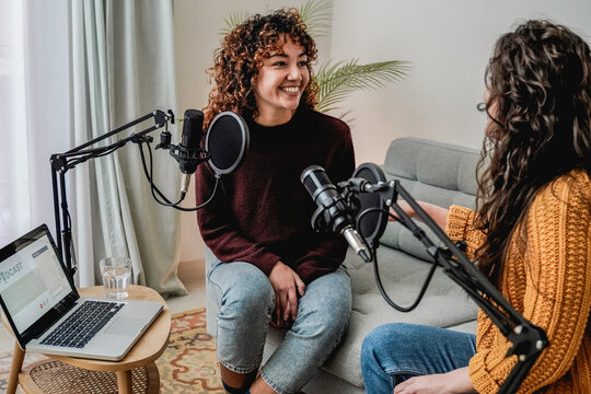 Female host recording radio podcast interview with guest at home office - Focus on latin woman face