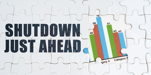 On white puzzles there is an inscription - Shutdown Just Ahead. Financial graph in the window among...