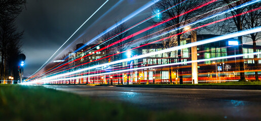 Fototapeta na wymiar Long exposure photo of a bus passing on a street at night.