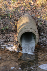 Water pipe with frozen water in a small creek.