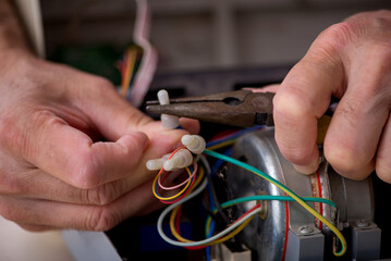 Old repairman repairing air-conditioner at workshop