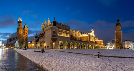 Krakow, Poland, main square snowy night panorama with Cloth Hall and St Mary's church