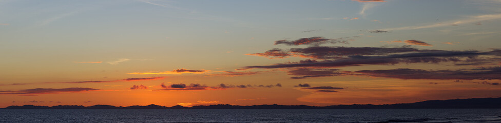 Panorama image of a dusk sky right after sunset over the Pacific Ocean shown in Panama.