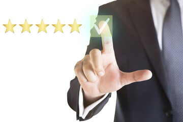 Businessman touching virtual screen on satisfaction rating icon in customer service and satisfaction concept. to give a good rating on the service That rating is a star icon.  