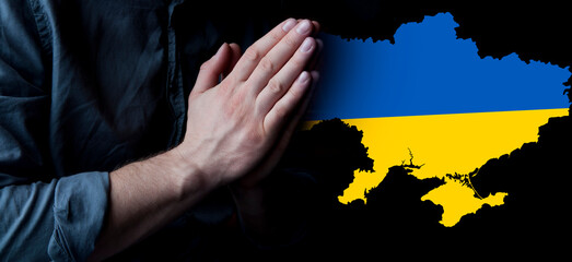 Hands in prayer. Prayer for Ukraine. Ukrainian flag. Prayer for the whole world. Europe and...