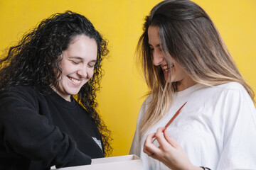 Couple of two girls opening valentine's day gifts