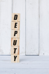 wooden cube, with the word deputy, with white wooden background