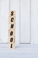 wooden cube, with the word school, with white wooden background