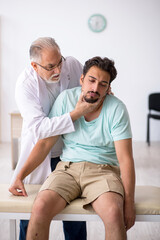 Obraz premium Young male patient visiting old male doctor