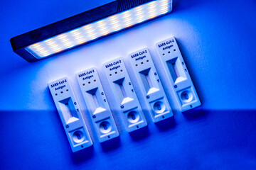 5 covid-19 antigen self-tests on a light background in blue tones. Medical concept - Mutated...