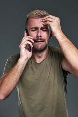 Terrible news a young man receives on his smart phone, feeling distressed and crying, humorous and exaggerated - 483195758