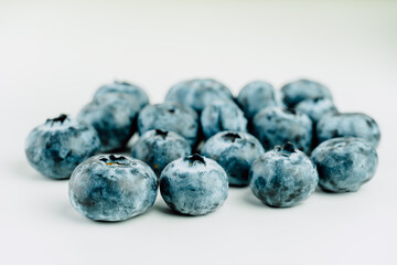 Close up view of group of fresh blueberries on a white background.