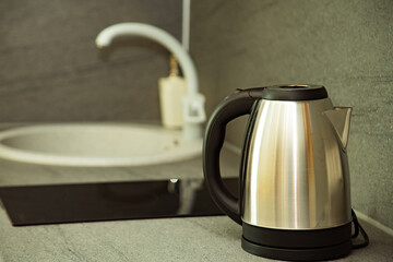 stylish, silver electric kettle is in the kitchen