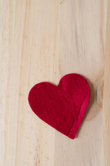 honest felt heart (with a bit of a crease) on a wooden surface with blank space