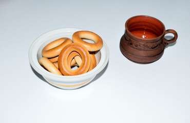 brown ceramic cup with coffee and bagels, close-up as texture for background