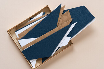 triangular shaped paper in white, blue, or brown in a shallow wooden box