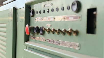 old electrical panel in abandoned factory with red button and shiny position switches. Machine control panel. Inscriptions in Russian FIBER OUTPUT, INNINGS, DRUMS, FLAP CONTROL, ADJUSTMENT