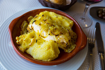 Delicate cod fish baked with mashed potatoes and onion served in pottery..