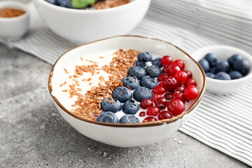 Bowl of sweet yogurt, flax seeds and berries on grunge background