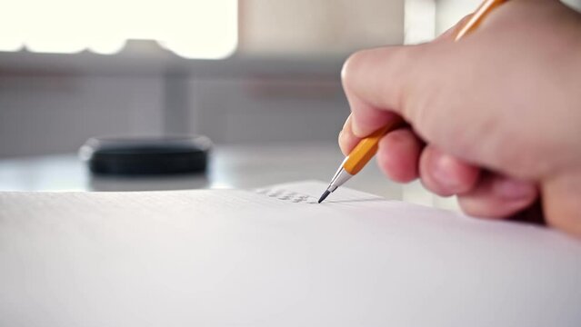 Caucasian Male Procrastinating Drawing Abstract Shapes in Square Ruled Notebook with Mechanical Pencil during Boring Meeting