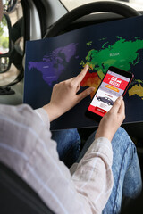 Woman holding mobile phone with open car rent app and map in automobile, closeup