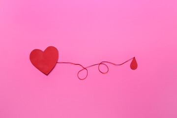 Red paper heart and drop of blood on color background. Donation concept