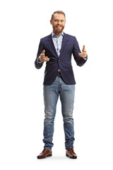 Full length portrait of a young man in suit and jeans smiling and explaining with hands
