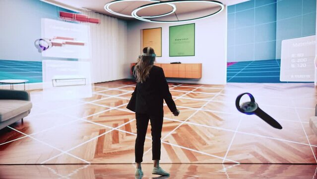 Interior Designer Using a VR Software to Design a Home, Try Different Colors, Move Furniture in Interactive Environment. Female Engineer Using Virtual Reality Headset and Controllers for Her Project.