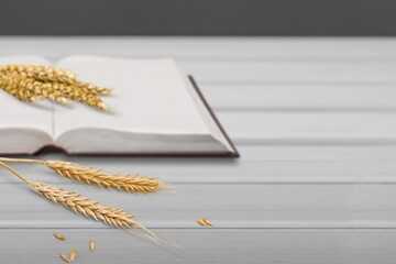 Golden ears of wheat with bible book on the desk