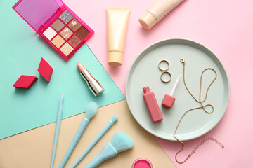 Plate with decorative cosmetics on color background