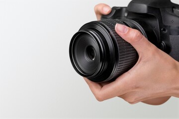 Photographer's hand with a black camera on background