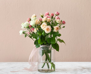 Vase with bouquet of beautiful roses on table