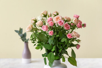 Vase with bouquet of beautiful roses on table