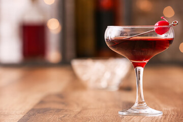 Glass of tasty Manhattan cocktail on wooden table, closeup