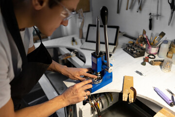 Close-up of ring. Jewelry tool for increasing and decreasing ring. Man tries on ring in tool. Blurred foreground.