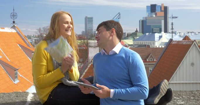 Man and woman using pad and map in city