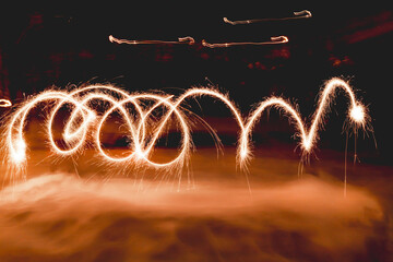 Spiral made with bengal fires. Bright sparkles shines in winter evening. Winter holiday...