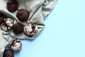 Tasty chocolate brownie cookies and napkin on blue background