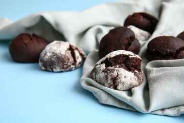 Tasty chocolate brownie cookies and napkin on blue background