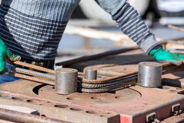 The worker is bending rebars with rebar bending machine in the site. The most common type of rebar...
