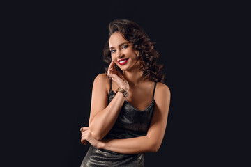 Young smiling woman with hand near face on dark background