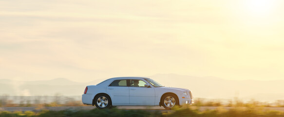 Car driving fast on intercity road at sunset. Highway traffic in evening